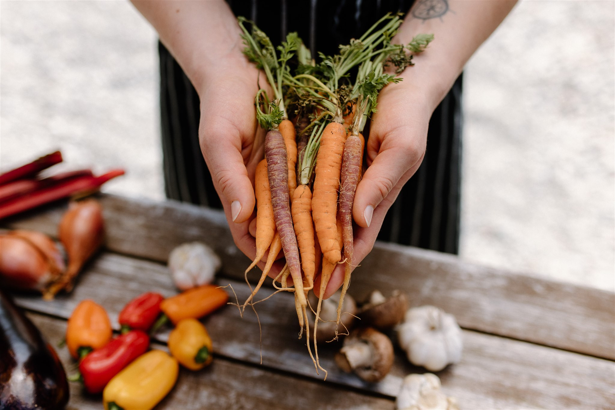 Hands holding carrots outside Edgewater Wanaka restaurant