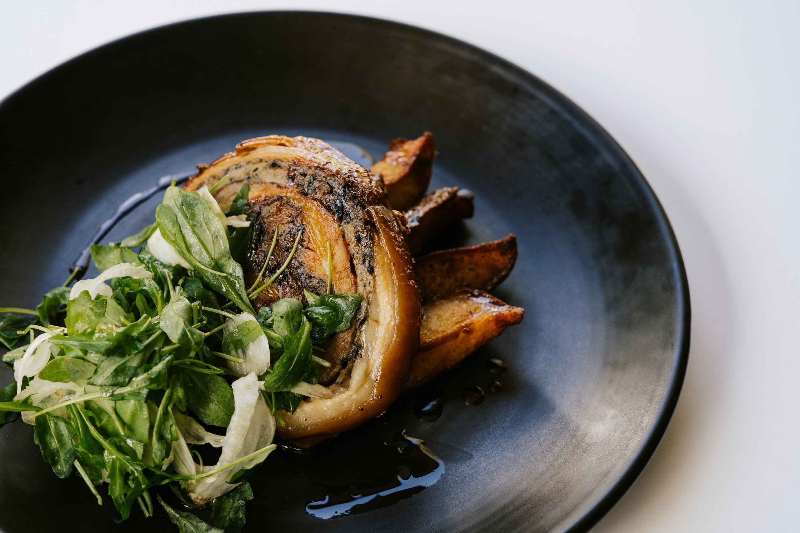 Wanaka food - pork belly plated with seasonal greens and apple sauce