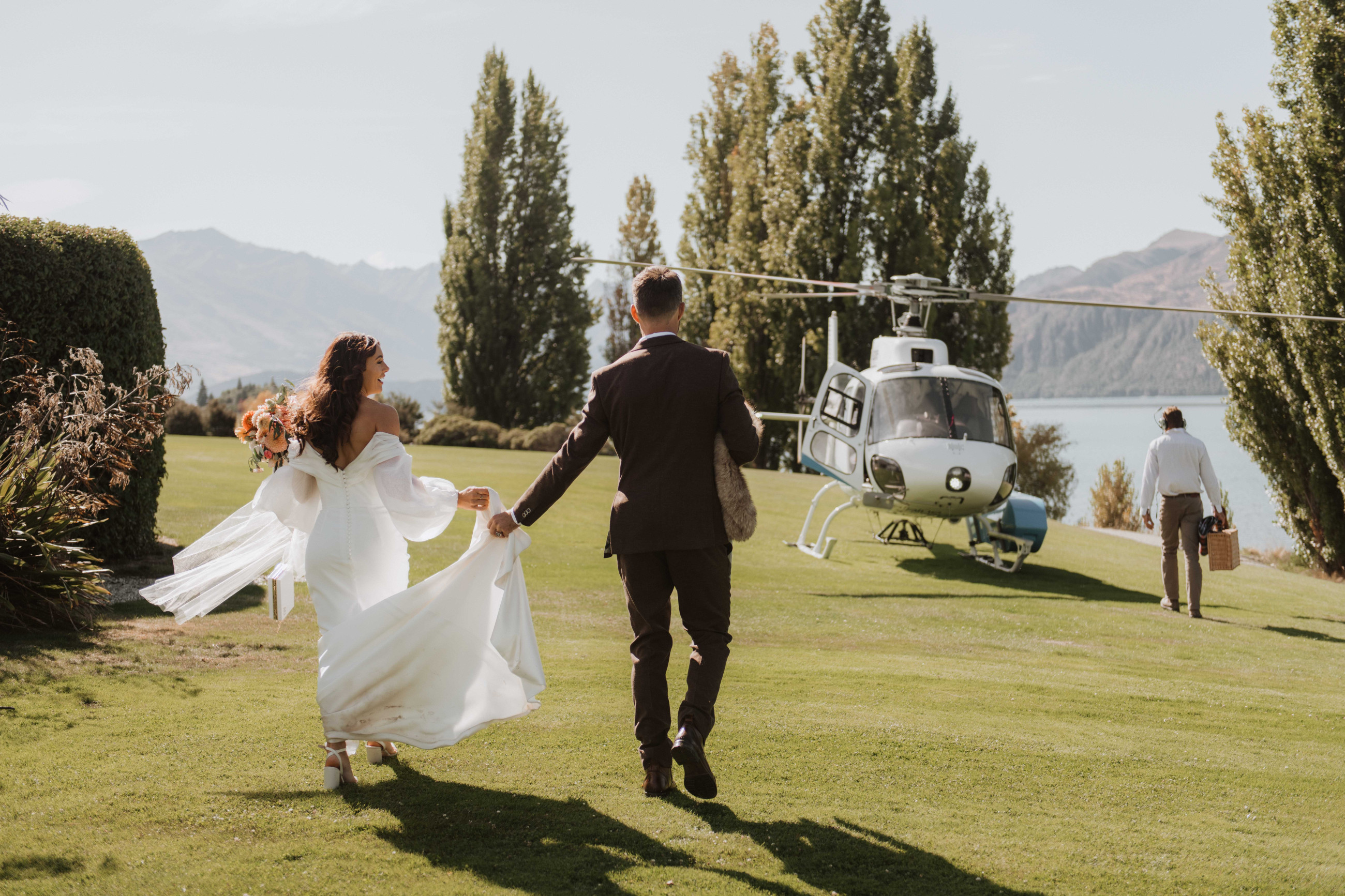 A&J being walking to their helicopter during their wanaka wedding