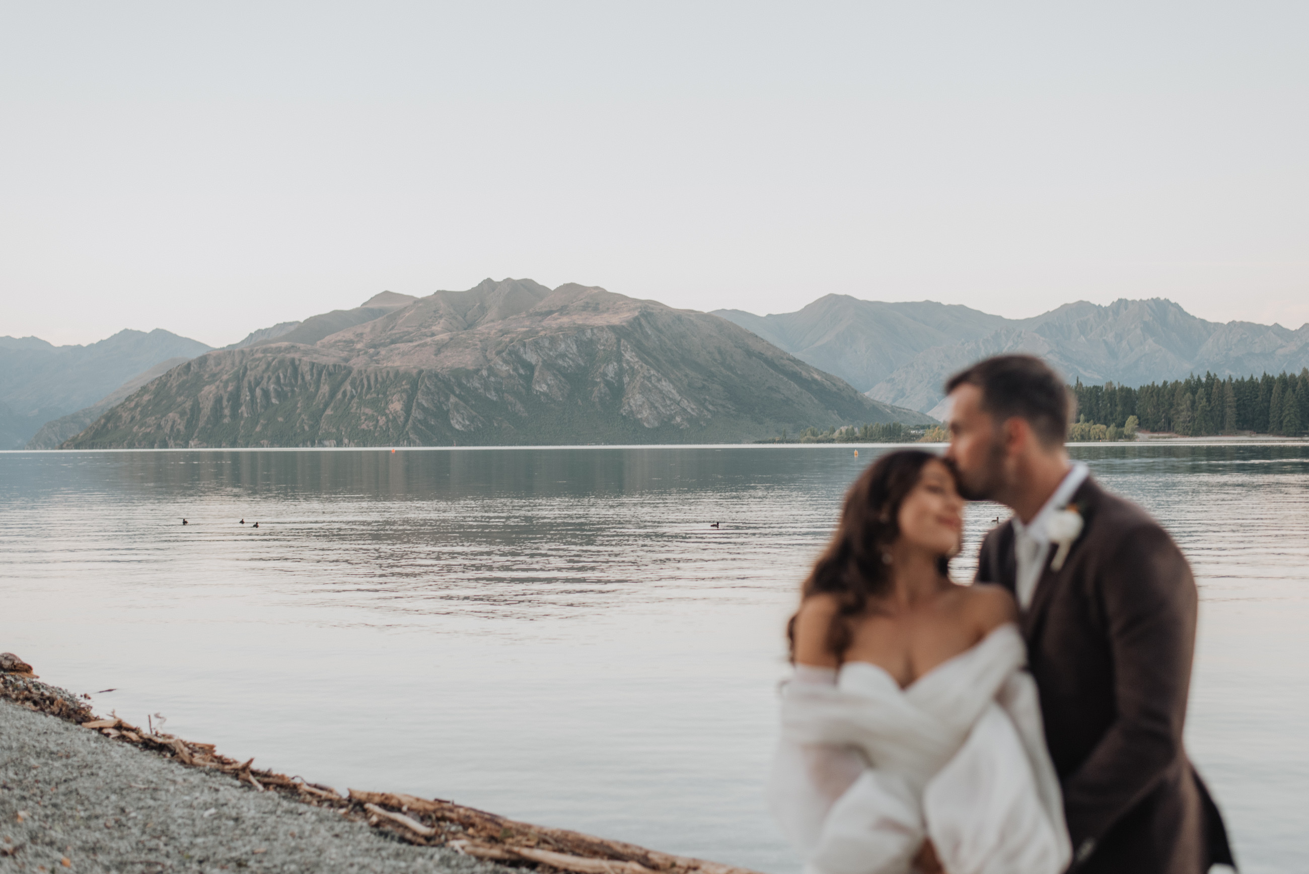 A&J posing in front of the lake front at their central otago wedding venue